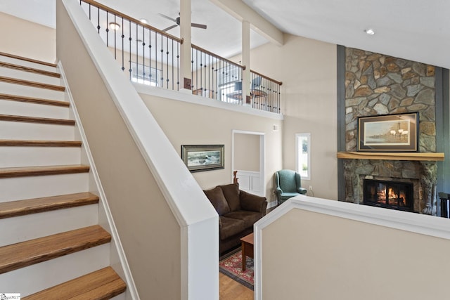 21 Pebble Creek Way, Taylors, SC 29687 - stairway with a stone fireplace, a ceiling fan, high vaulted ceiling, wood finished floors, and beamed ceiling