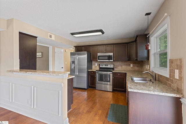 21 Pebble Creek Way, Taylors, SC 29687 - kitchen with appliances with stainless steel finishes, a sink, dark brown cabinetry, and decorative backsplash