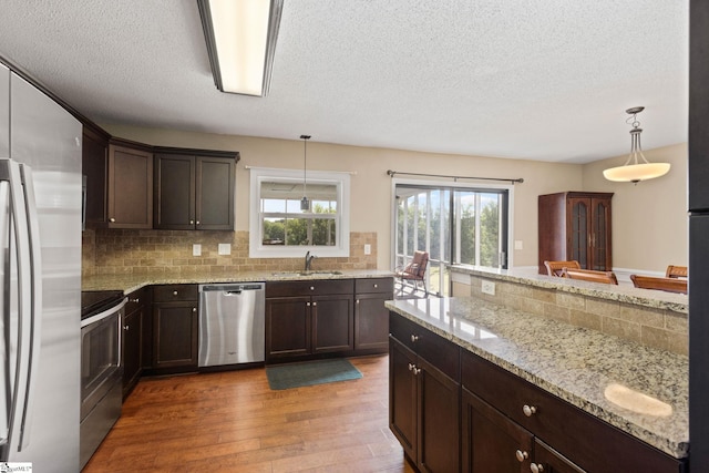 21 Pebble Creek Way, Taylors, SC 29687 - kitchen featuring stainless steel appliances, a sink, light wood finished floors, tasteful backsplash, and a textured ceiling