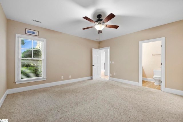 unfurnished bedroom featuring carpet floors, baseboards, connected bathroom, and a ceiling fan