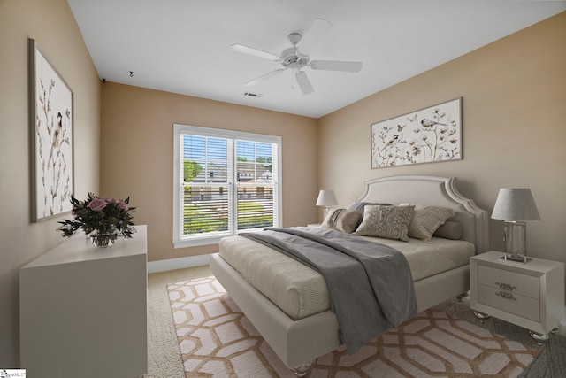 bedroom featuring light colored carpet, ceiling fan, and baseboards