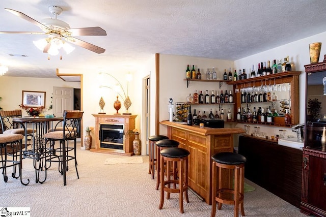521 N Calhoun Shores Pkwy, Calhoun Falls, SC 29628 - indoor dry bar featuring carpet, ceiling fan, a glass covered fireplace, and a textured ceiling