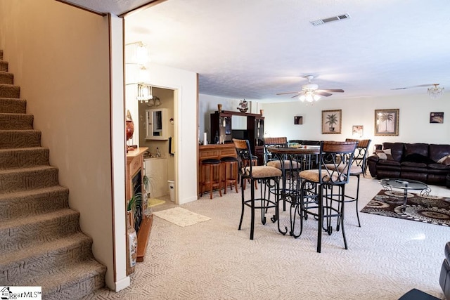 521 N Calhoun Shores Pkwy, Calhoun Falls, SC 29628 - dining area with stairway, light carpet, a ceiling fan, and a chandelier