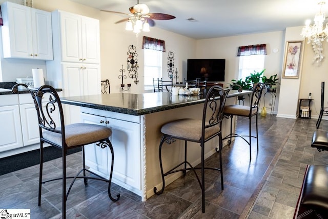521 N Calhoun Shores Pkwy, Calhoun Falls, SC 29628 - kitchen featuring a breakfast bar, a ceiling fan, white cabinetry, a center island, and a chandelier