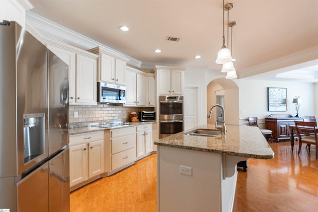 30 Kittery Dr, Greenville, SC 29615 - kitchen featuring appliances with stainless steel finishes, a sink, crown molding, a center island with sink, and light wood-style floors