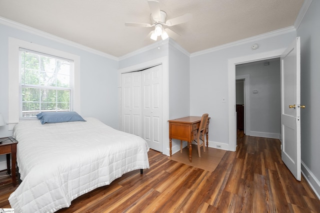 bedroom with wood finished floors, a closet, ornamental molding, baseboards, and ceiling fan