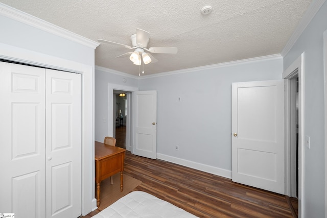 bedroom featuring dark wood-style flooring, a closet, baseboards, ornamental molding, and a textured ceiling