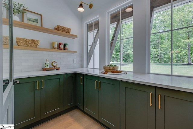 205 Fairview Dr, Greenville, SC 29609 - kitchen with green cabinetry, tasteful backsplash, open shelves, light wood-style floors, and light stone counters