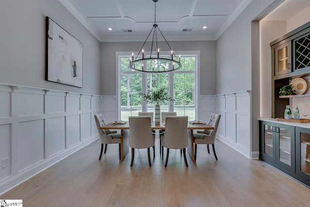 205 Fairview Dr, Greenville, SC 29609 - dining space featuring a decorative wall, a chandelier, light wood-type flooring, a wainscoted wall, and ornamental molding