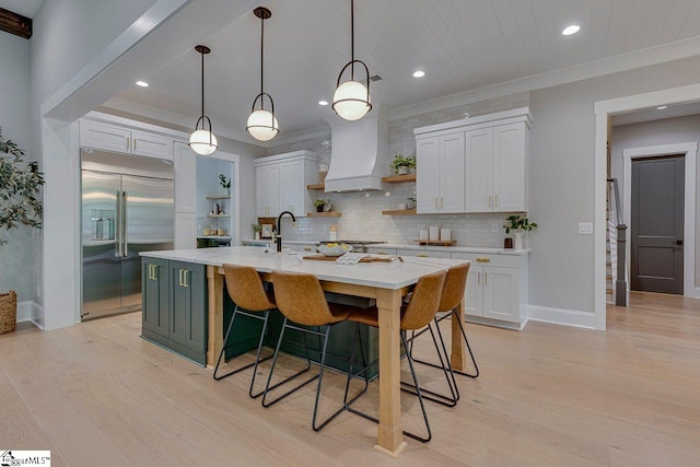 205 Fairview Dr, Greenville, SC 29609 - kitchen featuring built in fridge, open shelves, light wood-type flooring, custom exhaust hood, and white cabinets