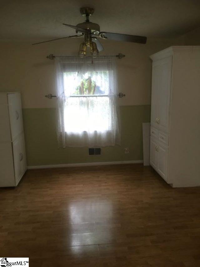 413 S Florida Ave, Greenville, SC 29611 - unfurnished bedroom with wood finished floors, baseboards, and ceiling fan