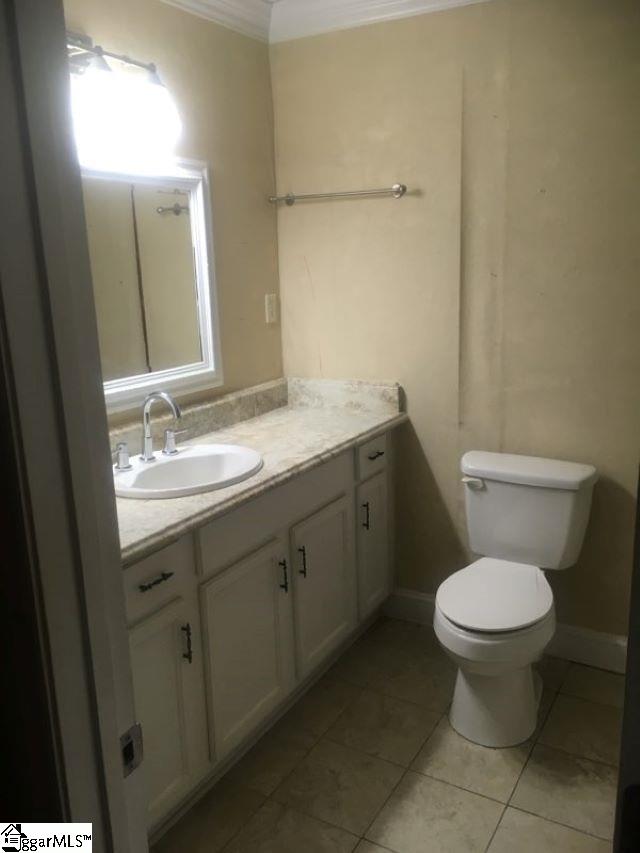 413 S Florida Ave, Greenville, SC 29611 - bathroom featuring vanity, toilet, ornamental molding, and tile patterned flooring