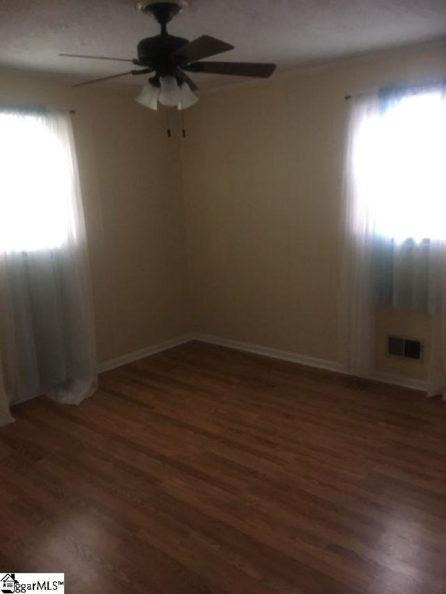 413 S Florida Ave, Greenville, SC 29611 - empty room with a ceiling fan, wood finished floors, plenty of natural light, and baseboards