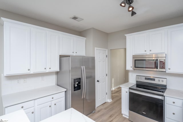 300 Stillwater Ct, Simpsonville, SC 29681 - kitchen with appliances with stainless steel finishes, backsplash, light countertops, light wood-style flooring, and white cabinetry