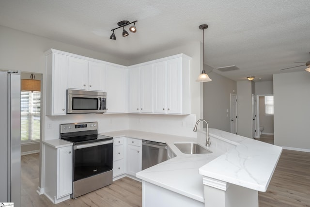 300 Stillwater Ct, Simpsonville, SC 29681 - kitchen featuring appliances with stainless steel finishes, a sink, a peninsula, healthy amount of natural light, and a textured ceiling
