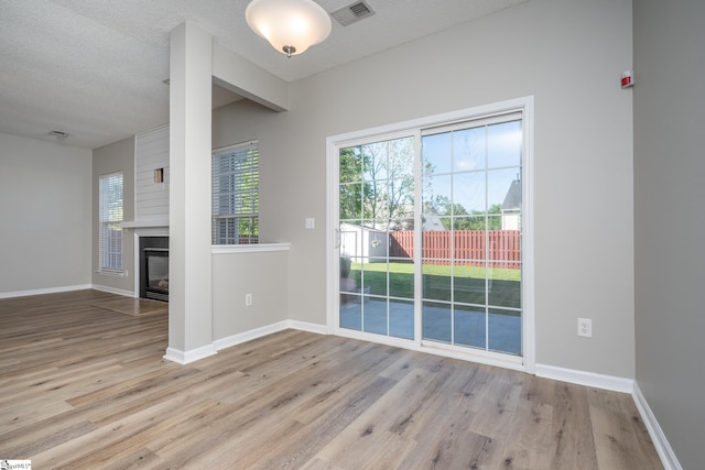 300 Stillwater Ct, Simpsonville, SC 29681 - unfurnished dining area with wood finished floors, baseboards, a textured ceiling, and a glass covered fireplace