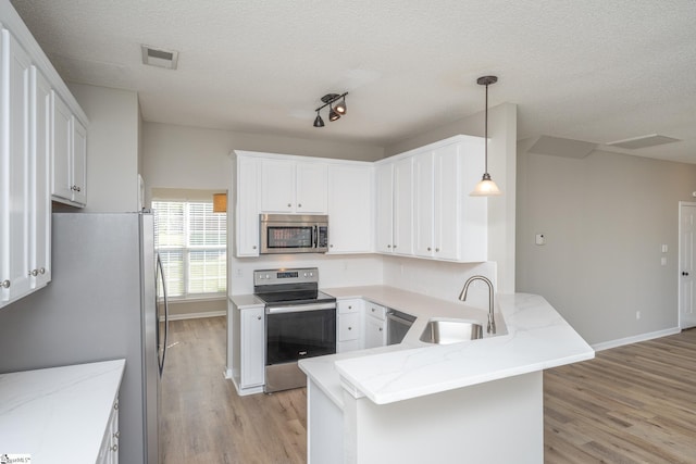 300 Stillwater Ct, Simpsonville, SC 29681 - kitchen featuring stainless steel appliances, a sink, a peninsula, light wood-style flooring, and white cabinets