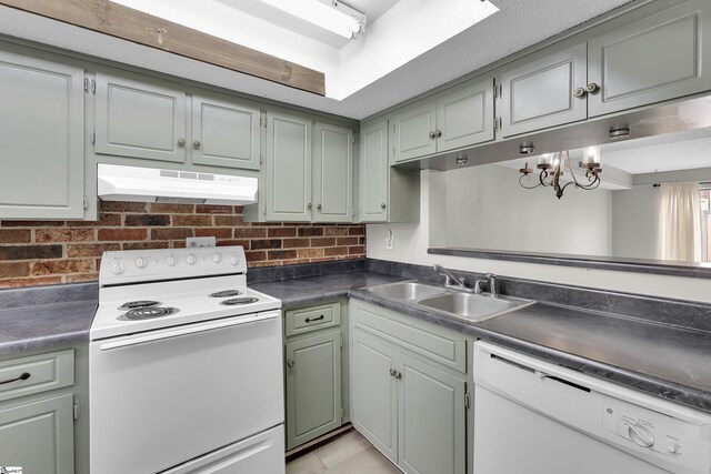 2530 E N St Unit 13K, Greenville, SC 29615 - kitchen with under cabinet range hood, white appliances, a sink, dark countertops, and a chandelier