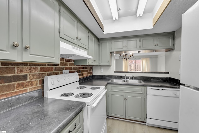 2530 E N St Unit 13K, Greenville, SC 29615 - kitchen featuring white appliances, under cabinet range hood, a sink, gray cabinets, and dark countertops