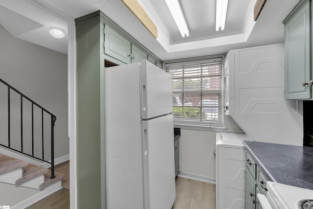2530 E N St Unit 13K, Greenville, SC 29615 - kitchen featuring freestanding refrigerator, light wood-type flooring, stove, dark countertops, and baseboards