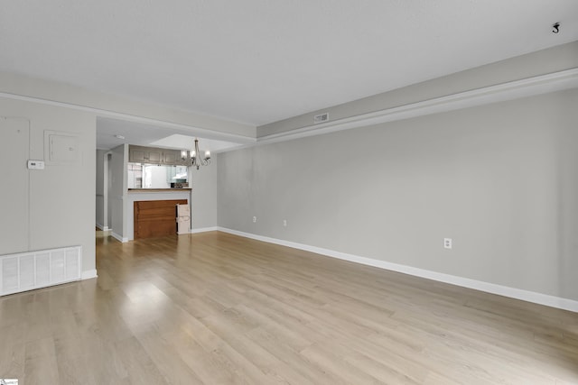 2530 E N St Unit 13K, Greenville, SC 29615 - unfurnished living room with a chandelier, baseboards, and light wood-style floors