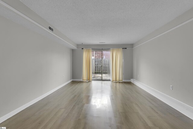 2530 E N St Unit 13K, Greenville, SC 29615 - spare room with a textured ceiling, wood finished floors, and baseboards