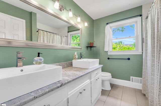 101 Kenilworth Ct, Greenville, SC 29615 - bathroom featuring toilet, double vanity, baseboards, and tile patterned flooring