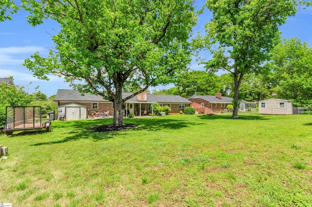 101 Kenilworth Ct, Greenville, SC 29615 - view of grassy yard with a storage unit, an outbuilding, and a trampoline