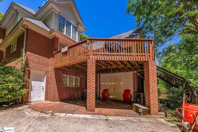 818 S Almond Dr, Simpsonville, SC 29681 - back of property with a wooden deck, brick siding, stairs, and roof with shingles