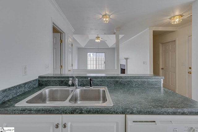 kitchen featuring a sink, dishwasher, a ceiling fan, dark countertops, and white cabinets