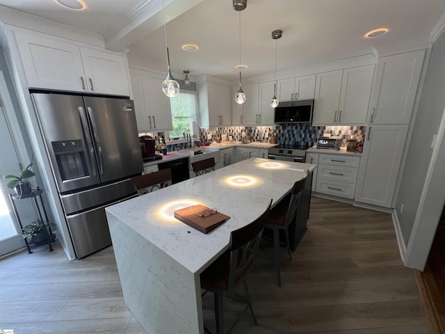 10 Dickens Ln, Taylors, SC 29687 - kitchen featuring stainless steel appliances, a center island, decorative backsplash, light wood-style flooring, and white cabinetry