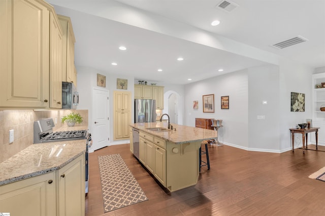 708 Emerald Hill Ct, Simpsonville, SC 29681 - kitchen with cream cabinets, stainless steel appliances, a sink, arched walkways, and a kitchen bar
