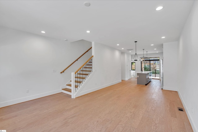 19 Conwell St, Greenville, SC 29601 - unfurnished living room with light wood-style floors, stairs, baseboards, and recessed lighting