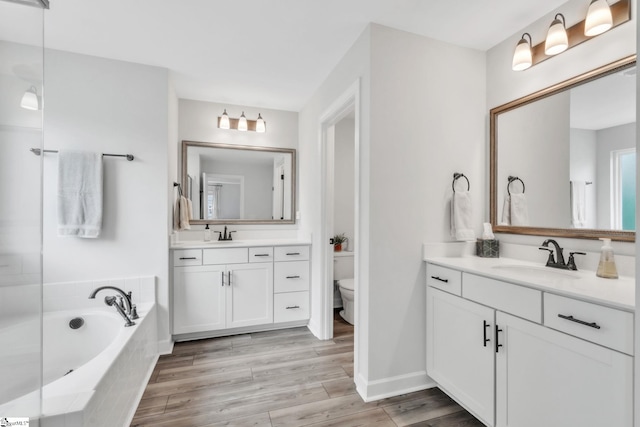 153 Coppermine Dr, Easley, SC 29642 - bathroom featuring a garden tub, two vanities, toilet, wood finished floors, and baseboards