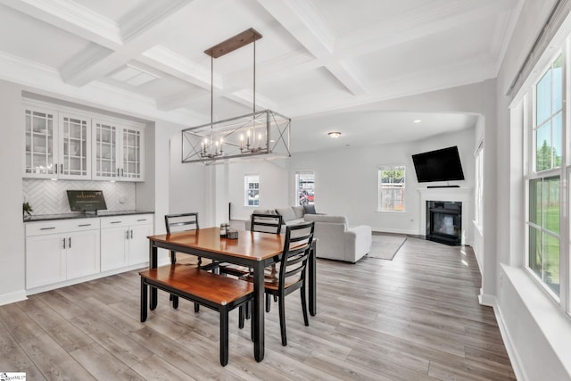 153 Coppermine Dr, Easley, SC 29642 - dining room with beam ceiling, coffered ceiling, light wood-style flooring, a chandelier, and a glass covered fireplace