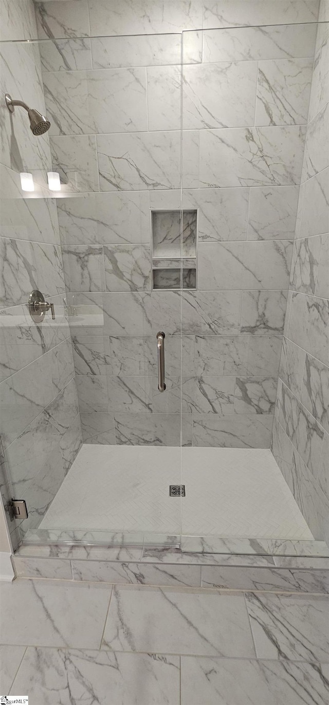 bathroom featuring a stall shower and marble finish flooring