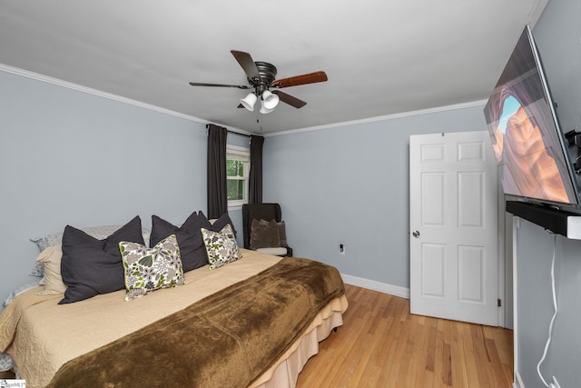 bedroom with light wood-style floors, baseboards, crown molding, and ceiling fan