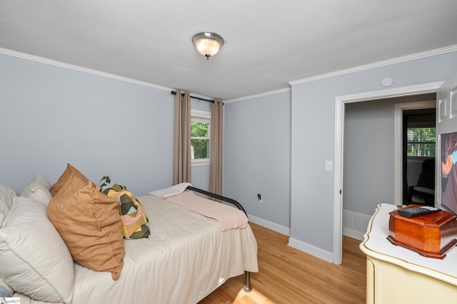 bedroom with baseboards, light wood-style floors, and ornamental molding