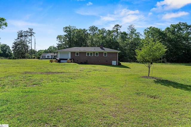 view of green lawn with an attached garage
