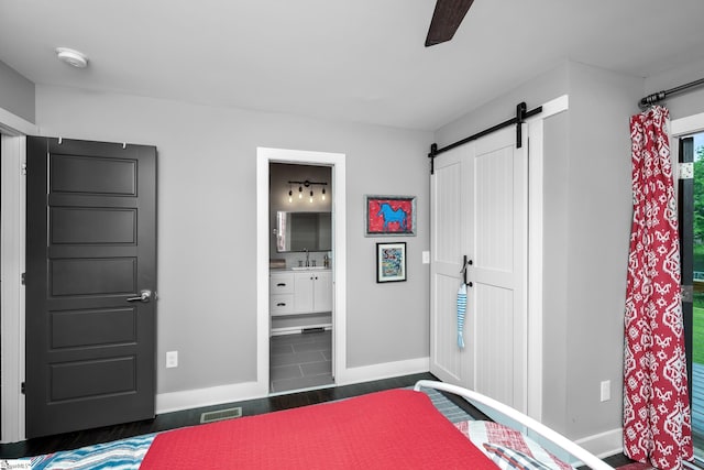 653 R B Baker Dr, Chapin, SC 29036 - bedroom with a barn door, baseboards, a sink, ensuite bathroom, and a ceiling fan
