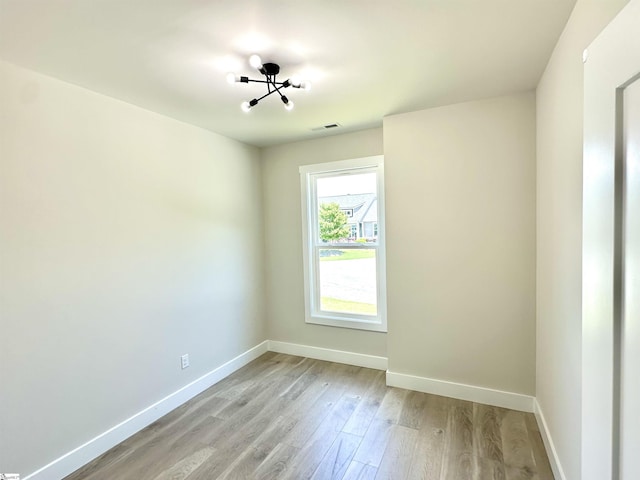 spare room featuring baseboards and light wood-type flooring