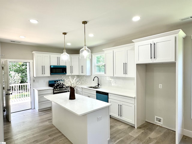 kitchen featuring stainless steel electric range, a sink, dishwasher, white cabinetry, and decorative backsplash