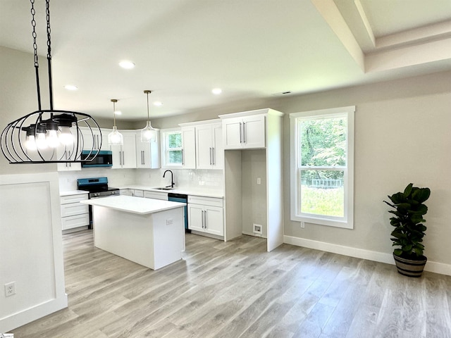 kitchen featuring stainless steel electric range, light wood-type flooring, recessed lighting, a center island, and white cabinets