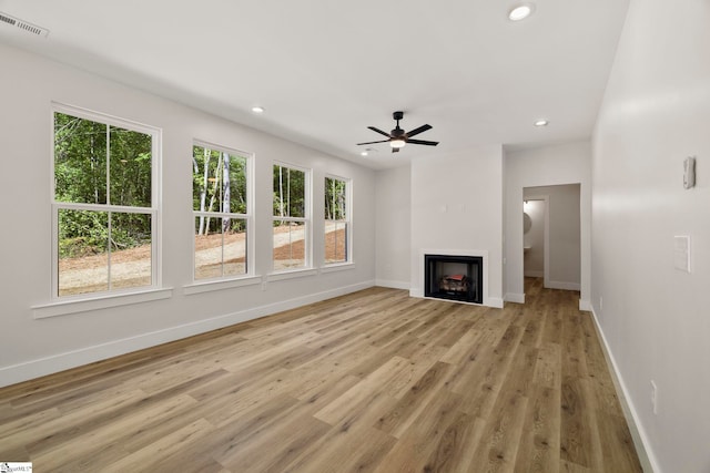 unfurnished living room featuring healthy amount of natural light, baseboards, ceiling fan, and recessed lighting