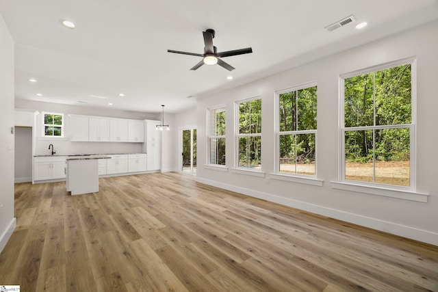 unfurnished living room featuring baseboards, a sink, a ceiling fan, recessed lighting, and light wood-style flooring
