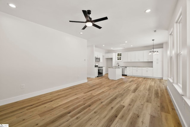 unfurnished living room featuring a sink, recessed lighting, a ceiling fan, light wood-style floors, and baseboards