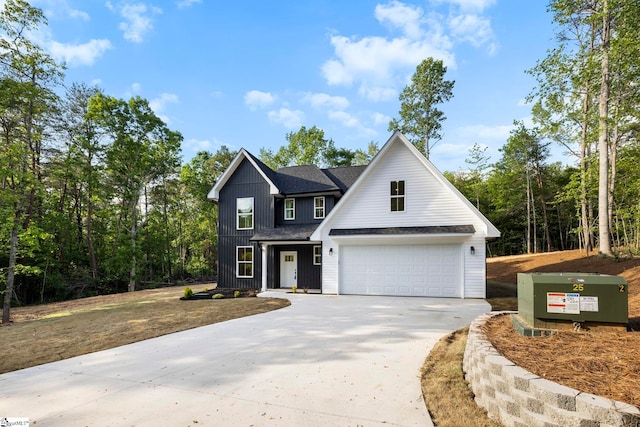 modern farmhouse featuring concrete driveway, a shingled roof, and an attached garage