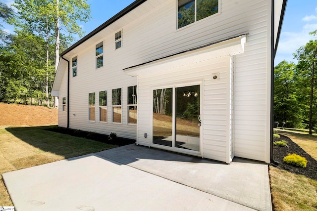 rear view of house featuring a patio area and a lawn