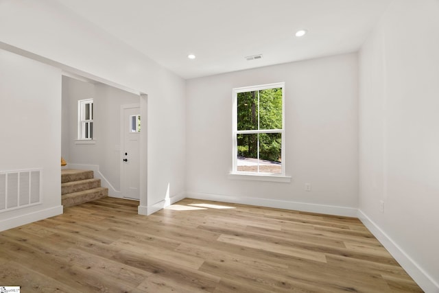 unfurnished room featuring stairway, baseboards, light wood-type flooring, and recessed lighting