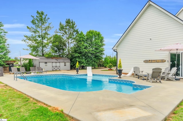 view of swimming pool featuring a patio area, an outdoor structure, and a storage shed